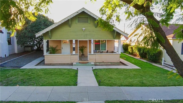 bungalow-style house with covered porch and a front lawn