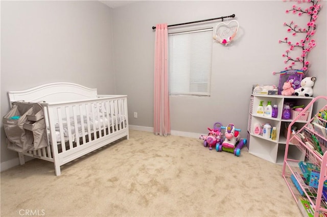 carpeted bedroom featuring a nursery area and baseboards