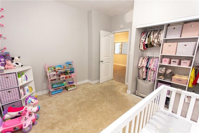 carpeted bedroom featuring a closet and baseboards