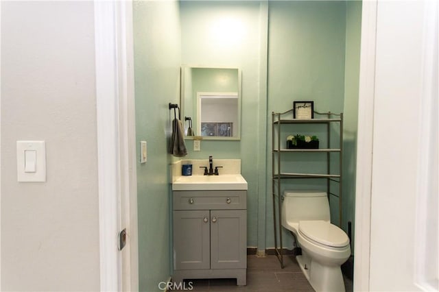 bathroom with toilet, wood finished floors, and vanity