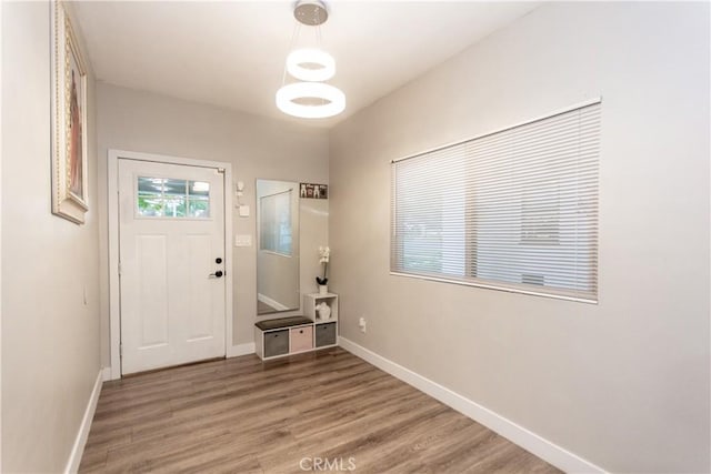 foyer with light wood-style flooring and baseboards