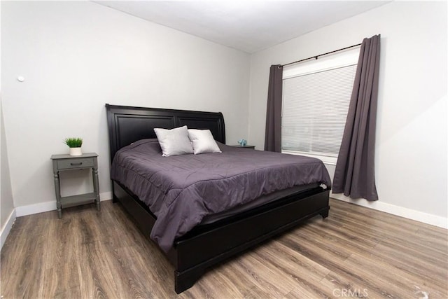 bedroom with wood finished floors and baseboards