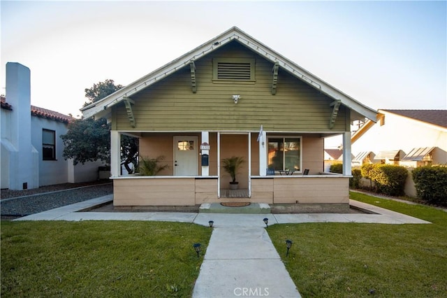 bungalow-style house with covered porch and a front yard