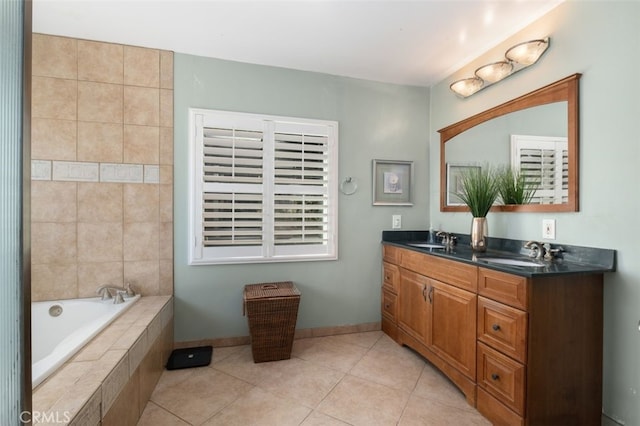 full bathroom with double vanity, a relaxing tiled tub, a sink, and tile patterned floors