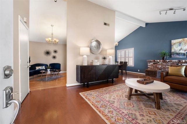 living room with baseboards, visible vents, beamed ceiling, wood finished floors, and an inviting chandelier