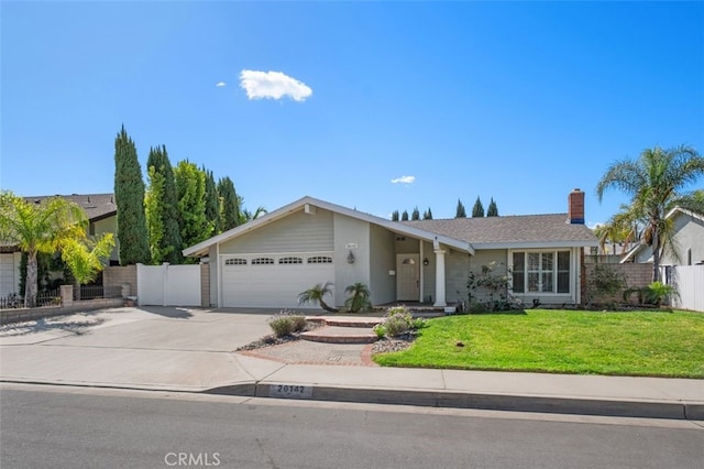 view of front of property featuring concrete driveway, fence, a front lawn, and an attached garage