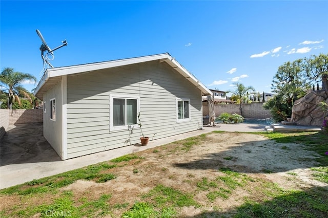 view of side of property with a fenced backyard and a patio