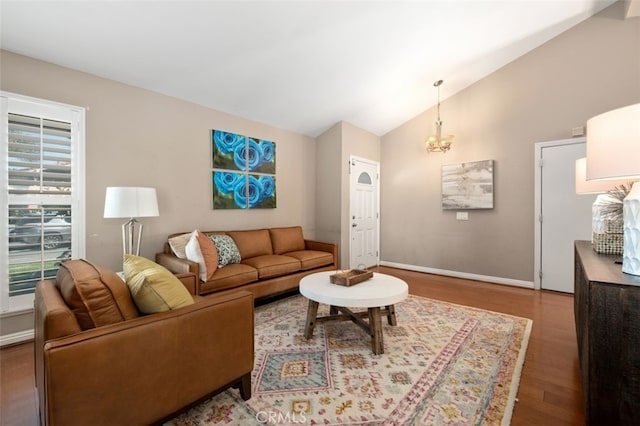 living area featuring an inviting chandelier, baseboards, vaulted ceiling, and wood finished floors