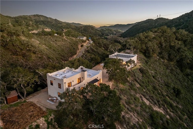 aerial view at dusk with a wooded view and a mountain view