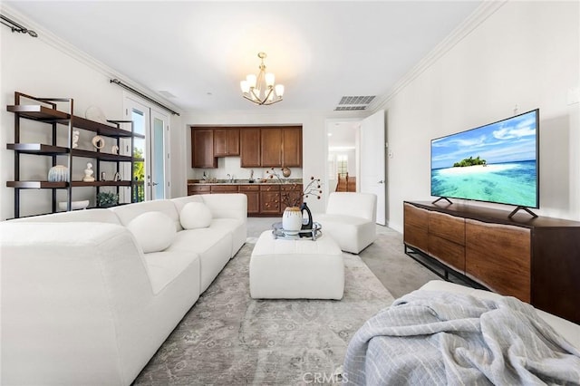 living area with crown molding, a chandelier, and visible vents