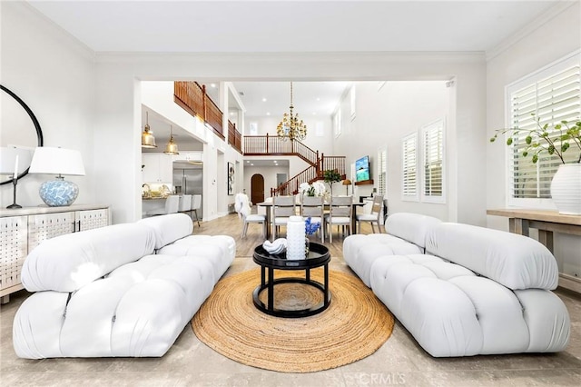 living area with a notable chandelier, stairs, and ornamental molding