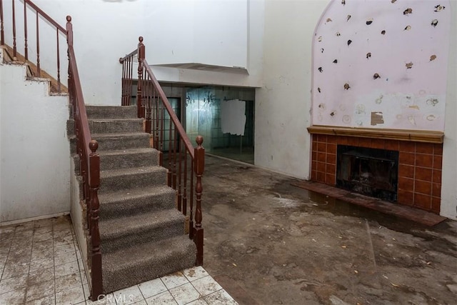 interior space featuring stairs and a tile fireplace