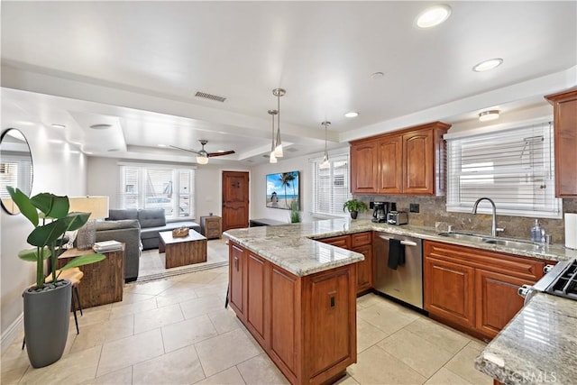 kitchen featuring a peninsula, a sink, visible vents, dishwasher, and a tray ceiling