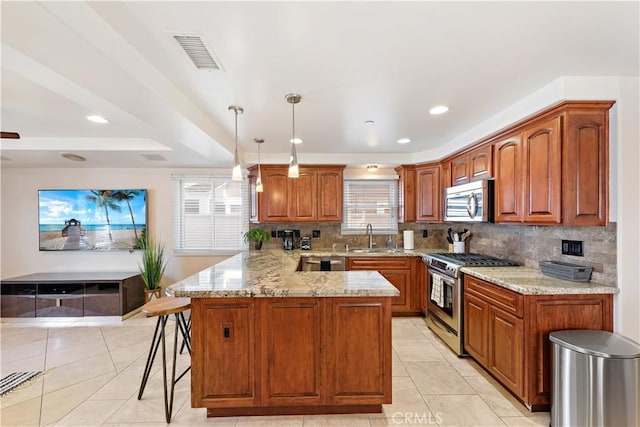 kitchen with visible vents, a peninsula, light stone countertops, stainless steel appliances, and a sink