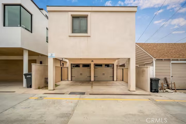 view of front of house with a garage, fence, and stucco siding