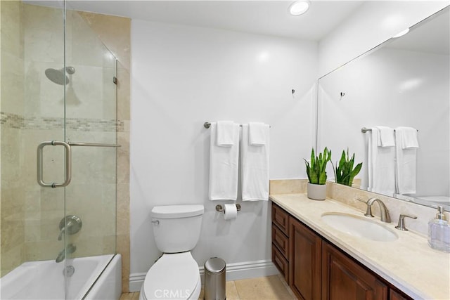 full bathroom featuring baseboards, combined bath / shower with glass door, vanity, and toilet