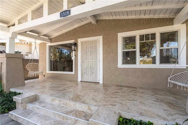 view of exterior entry with stucco siding