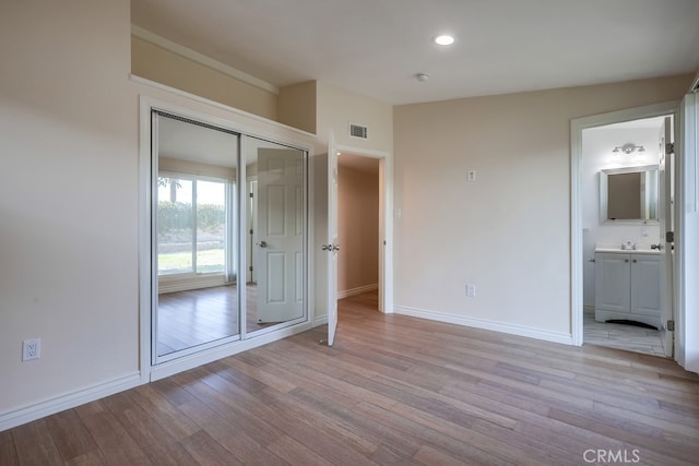 unfurnished bedroom with recessed lighting, a closet, visible vents, light wood-style flooring, and baseboards