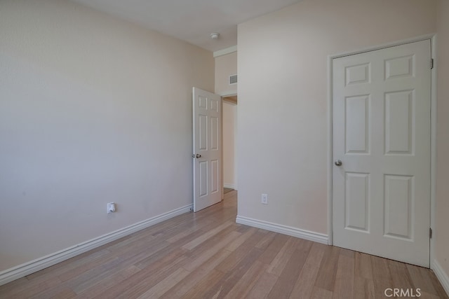 unfurnished bedroom with light wood-style flooring and baseboards