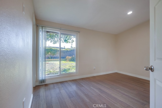 empty room featuring plenty of natural light, baseboards, and wood finished floors