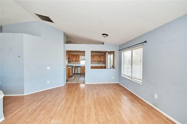 unfurnished living room with light wood-style floors, baseboards, visible vents, and vaulted ceiling