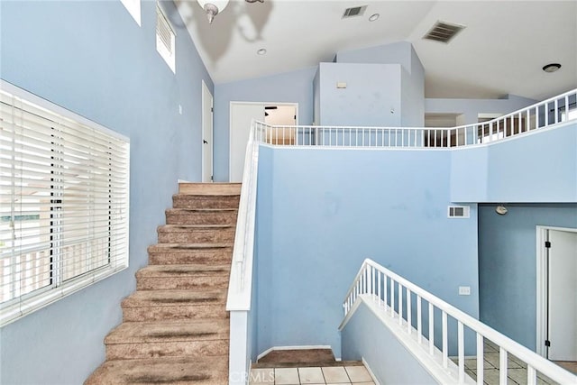 staircase with high vaulted ceiling and visible vents