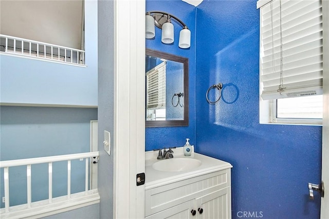 bathroom with a textured wall and vanity