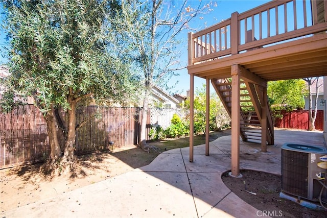 view of patio featuring cooling unit, a fenced backyard, and stairway