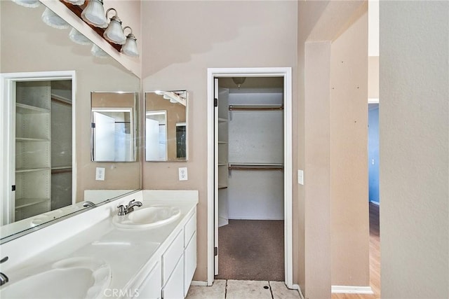 bathroom with tile patterned flooring, a sink, and double vanity