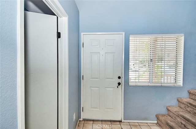 entryway with stairway and light tile patterned flooring