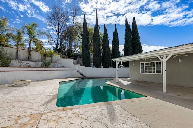 view of pool featuring a ceiling fan, a patio, a fire pit, and a fenced backyard