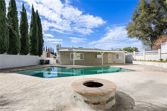 view of pool with a patio area, a fenced in pool, a fenced backyard, and an outdoor fire pit