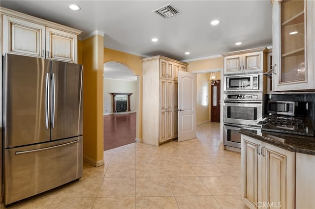 kitchen with visible vents, backsplash, appliances with stainless steel finishes, light tile patterned flooring, and crown molding