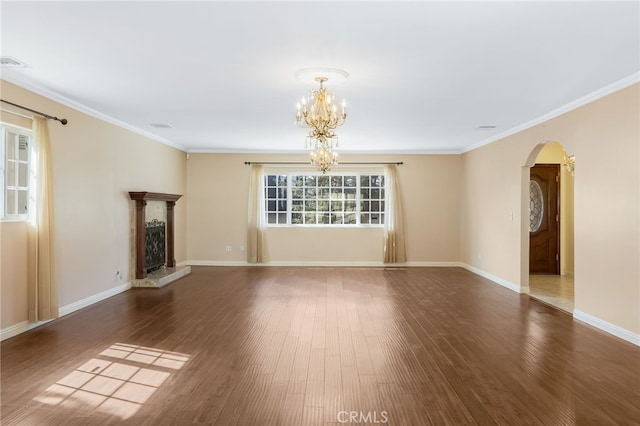 unfurnished living room with wood finished floors, visible vents, arched walkways, ornamental molding, and a chandelier