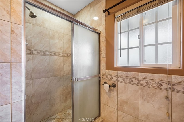 bathroom featuring a shower stall and tile walls