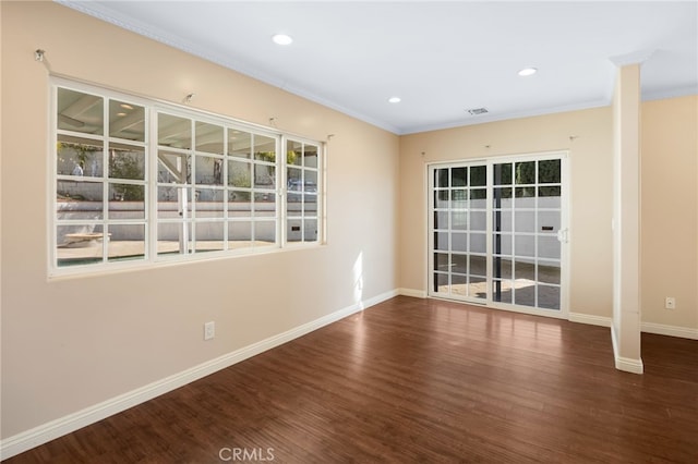 empty room featuring recessed lighting, crown molding, baseboards, and wood finished floors