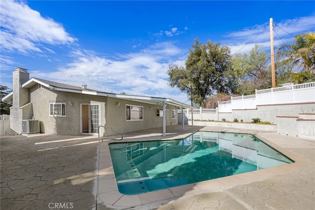 view of pool with cooling unit, a patio area, a fenced in pool, and a fenced backyard