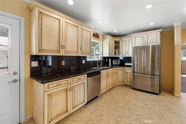 kitchen featuring a sink, stainless steel appliances, tasteful backsplash, and light brown cabinets