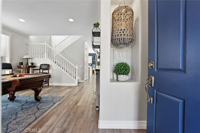 entrance foyer featuring billiards, wood finished floors, baseboards, recessed lighting, and stairs