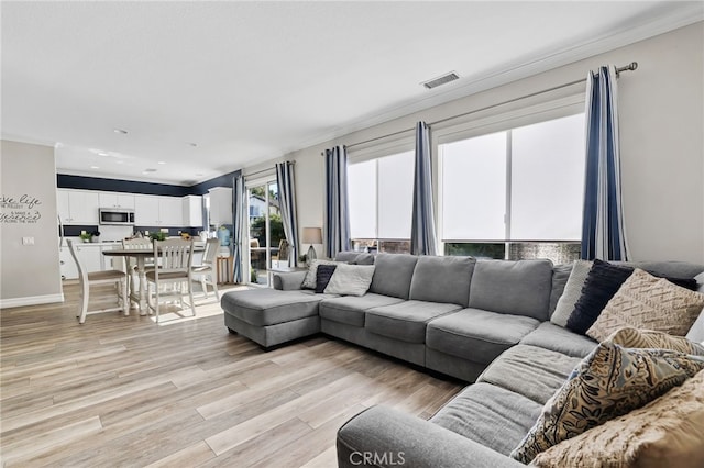 living room with visible vents, light wood-type flooring, and baseboards