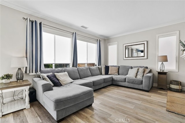 living room featuring light wood-type flooring, visible vents, and ornamental molding