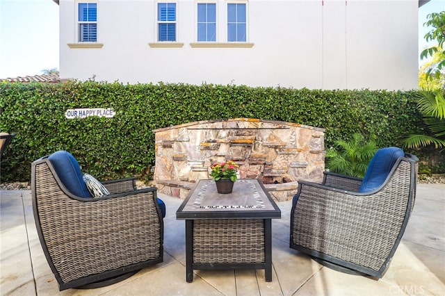 view of patio with an outdoor living space with a fireplace