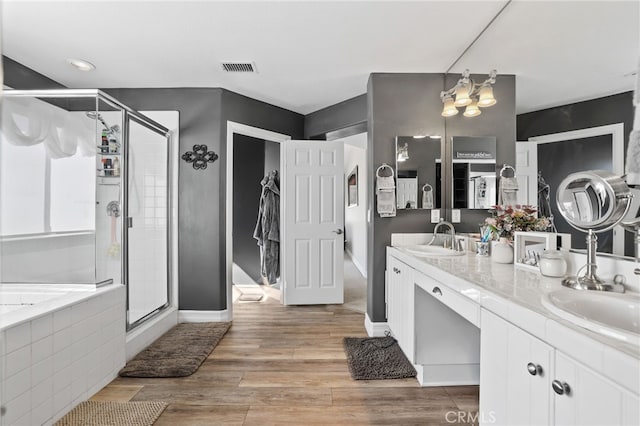 full bathroom with a stall shower, wood finished floors, and a sink