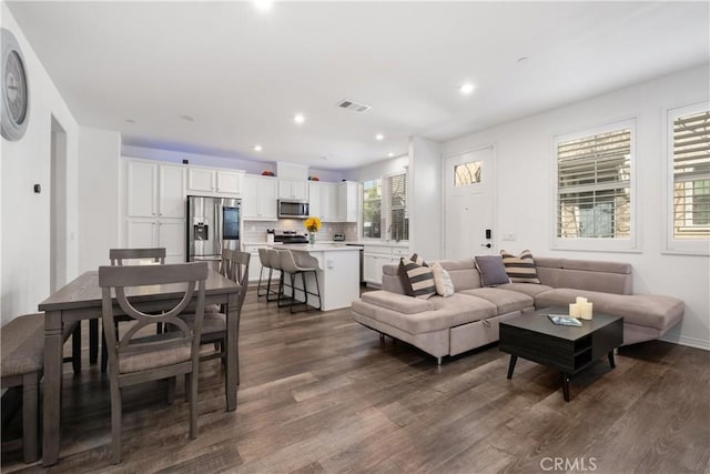 living room with recessed lighting, dark wood-style flooring, and visible vents