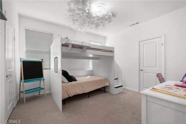 bedroom featuring visible vents and light colored carpet