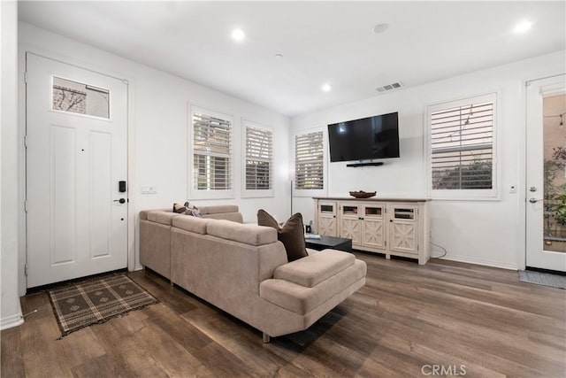 living area with dark wood-style floors, recessed lighting, visible vents, and baseboards