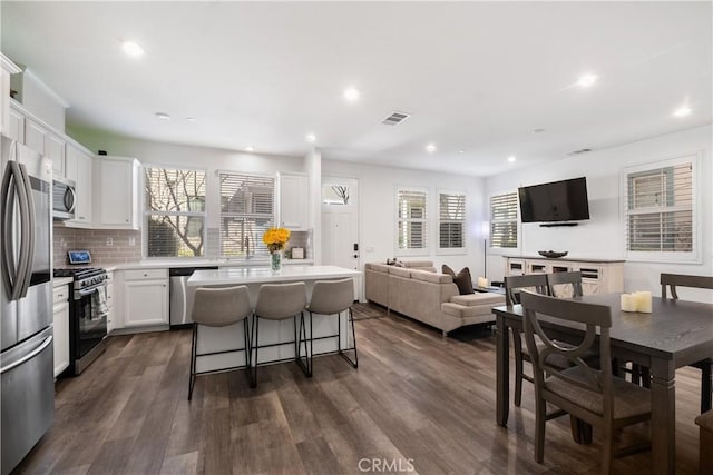 166 Natal Rd, Rancho Mission Viejo, CA 92694 - kitchen with stainless steel appliances, a kitchen bar, a kitchen island, backsplash, and white cabinets