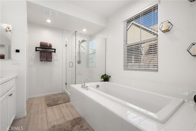 full bath with a stall shower, visible vents, a garden tub, and vanity