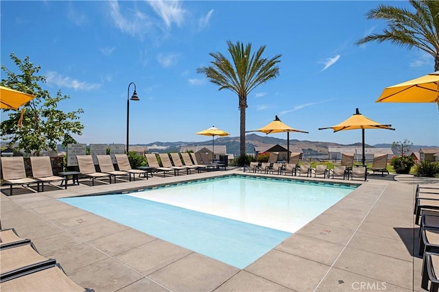 view of swimming pool with a patio and a mountain view