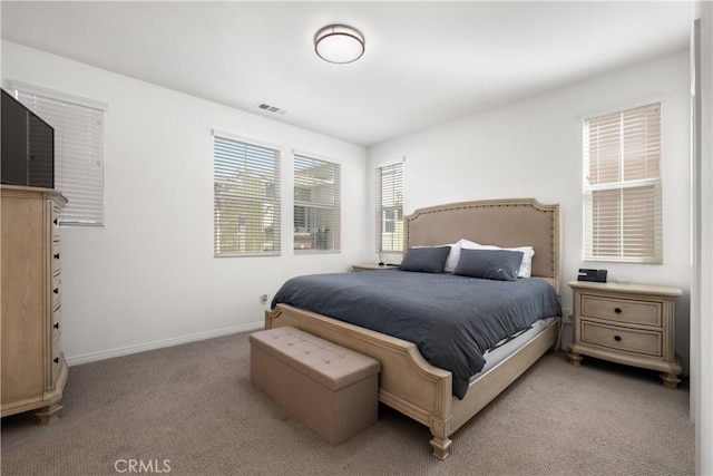 bedroom with visible vents, light carpet, and baseboards